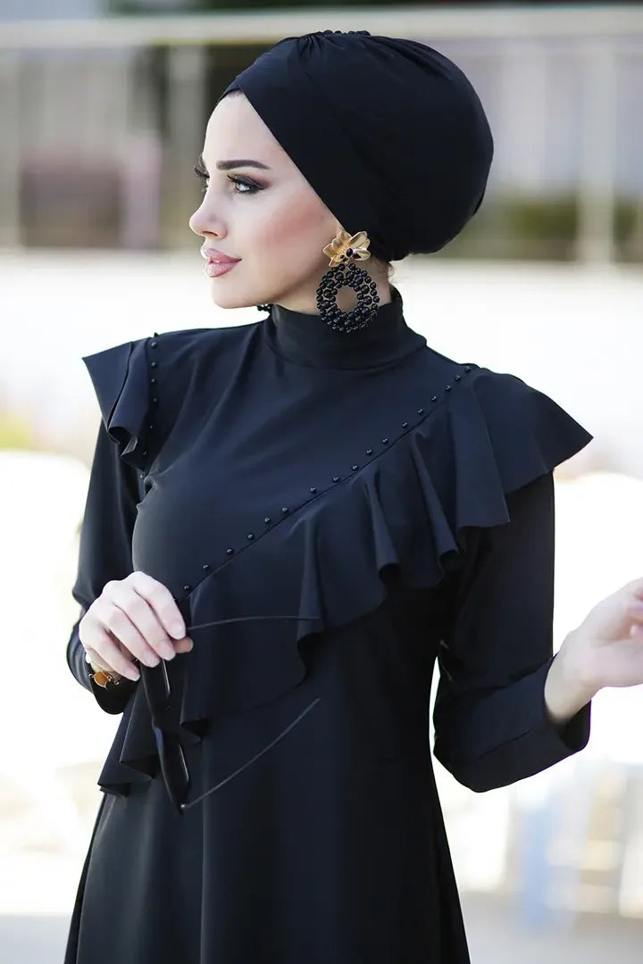 Back view of navy modest bathing suit with full-length leggings and cap