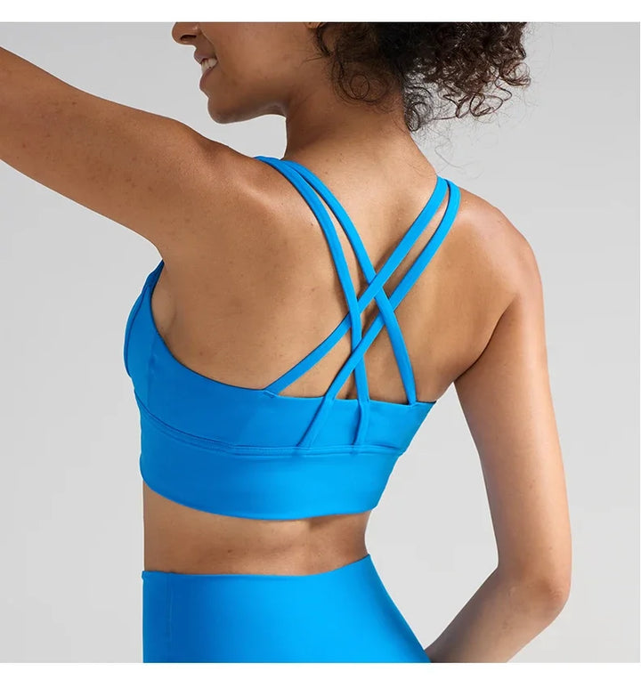 Blue sports bra with criss-cross back design on a neutral background