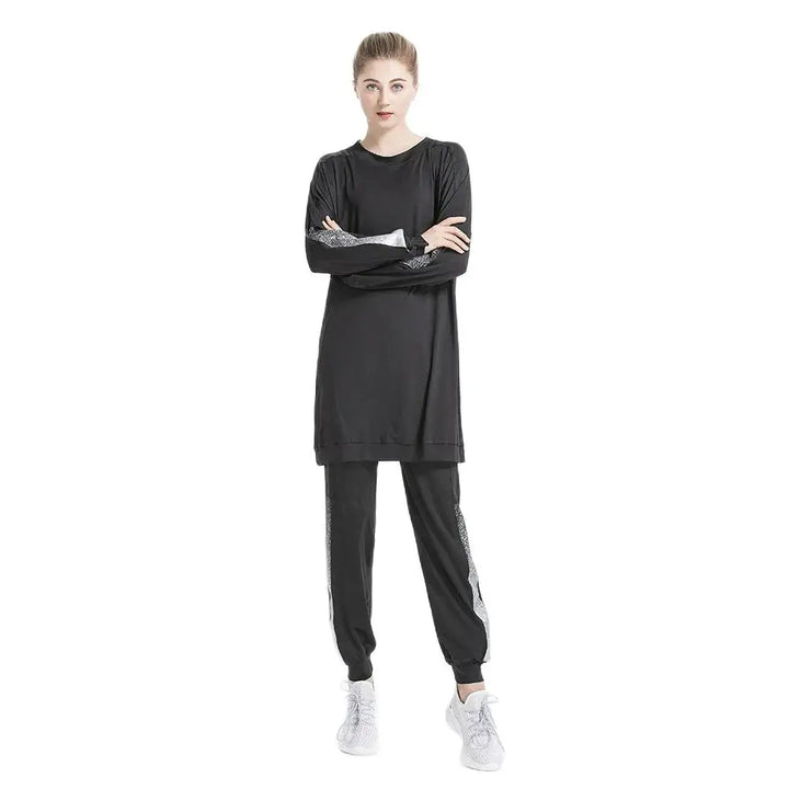 Model wearing modest athletic wear in black with colorblock sleeve and leggings