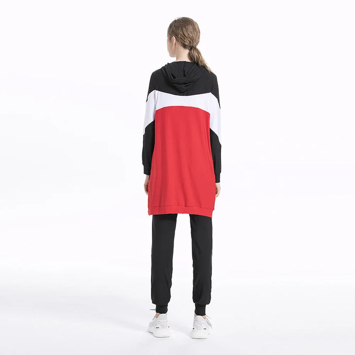 Person wearing a black, white, and red color-blocked hoodie and pants on a white background