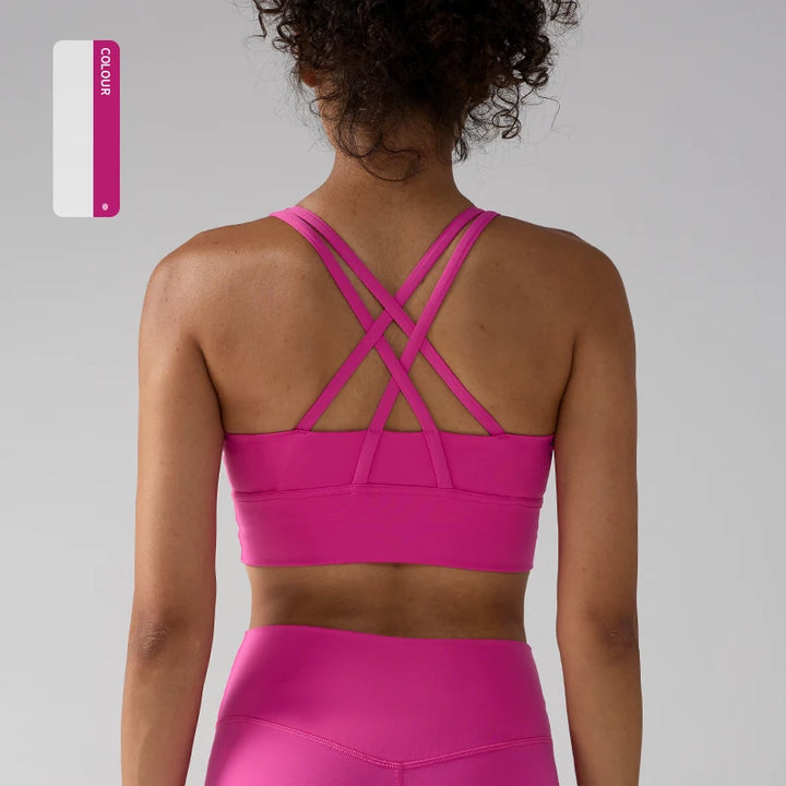 Person wearing a bright pink sports bra and leggings on a gray background