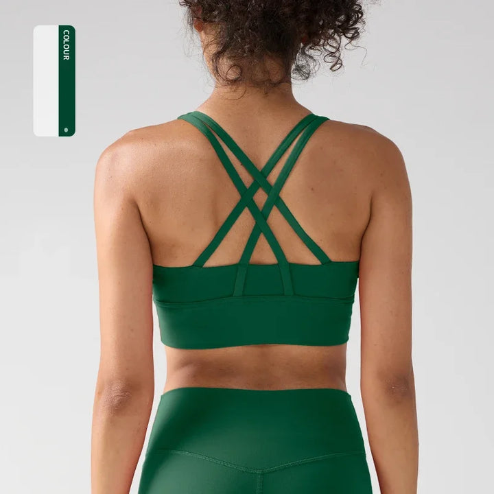 Person wearing a green sports bra and leggings on a light gray background