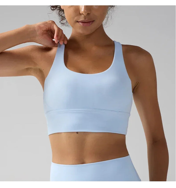 Person wearing a light blue sports bra and leggings on a plain background