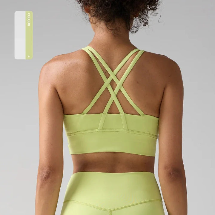 Person wearing a light green sports bra and leggings set on a gray background