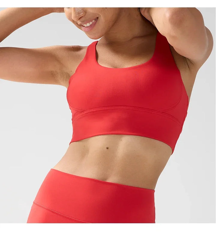 Person wearing a red sports bra and leggings on a light gray background