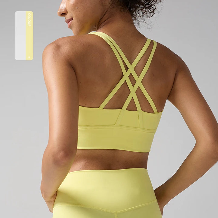 Person wearing a yellow sports bra and leggings on a gray background