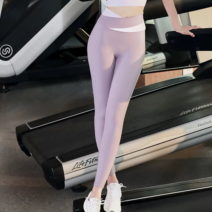 Person wearing light purple leggings standing on a treadmill in a gym setting
