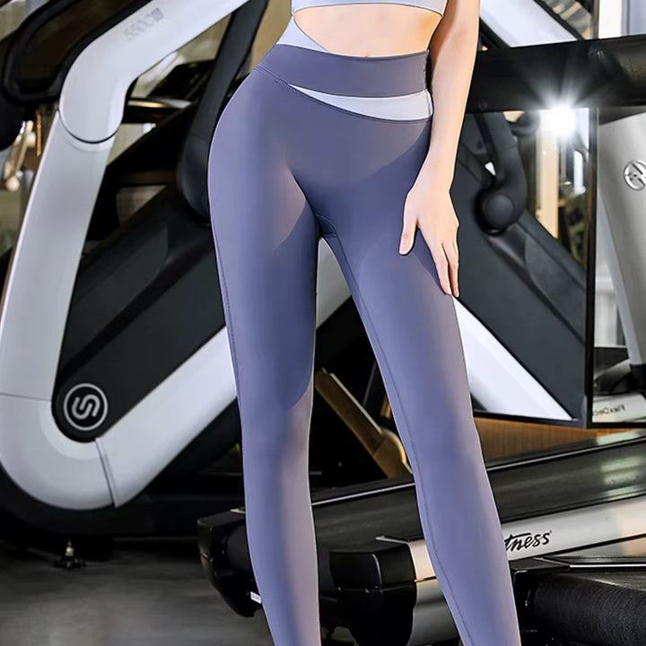 Person wearing purple leggings standing in front of a gym machine.
