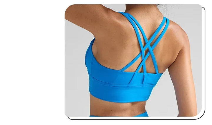 Blue sports bra with criss-cross straps on a neutral background