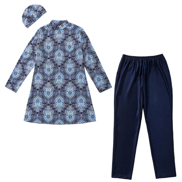 Set of blue patterned burkini, navy pants, and matching headscarf on a white background