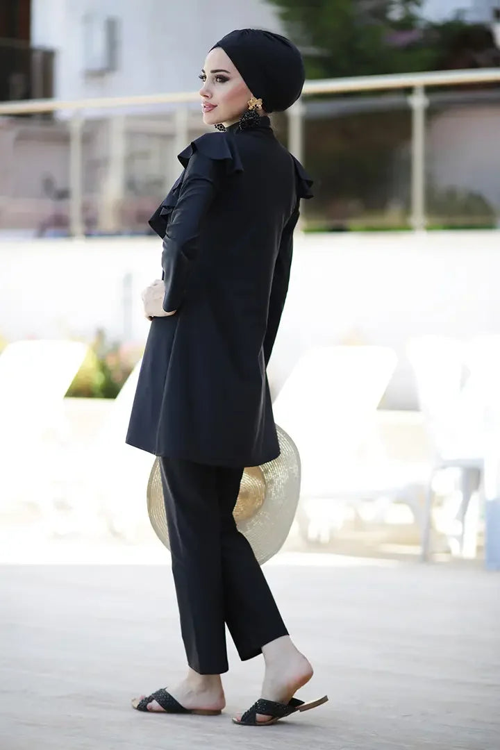 Side profile showing full coverage design and flow of ruffle on modest swimwear