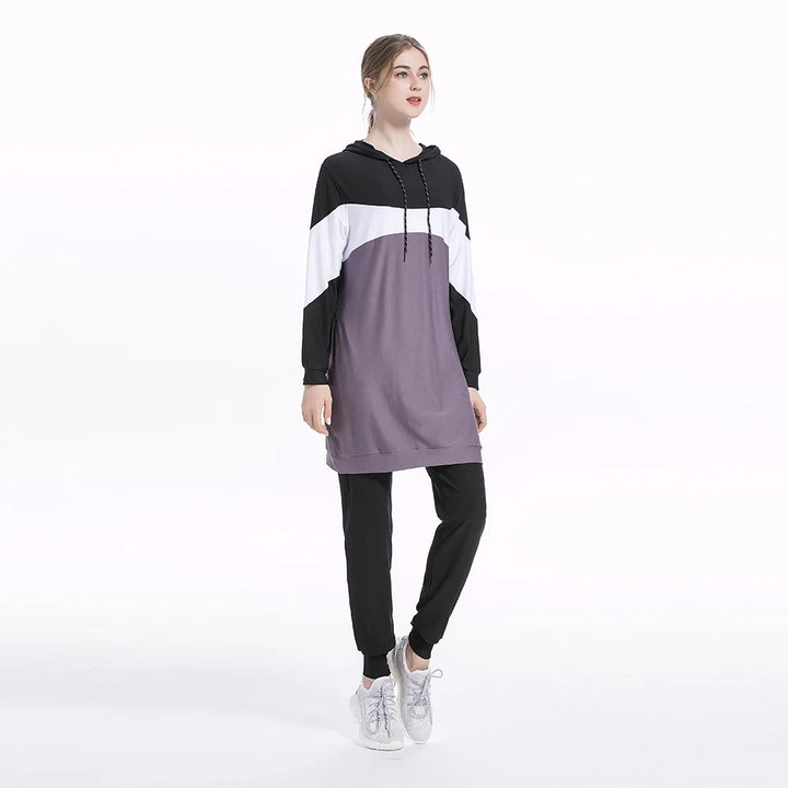 Woman wearing a black, white, and gray color-blocked outfit on a white background