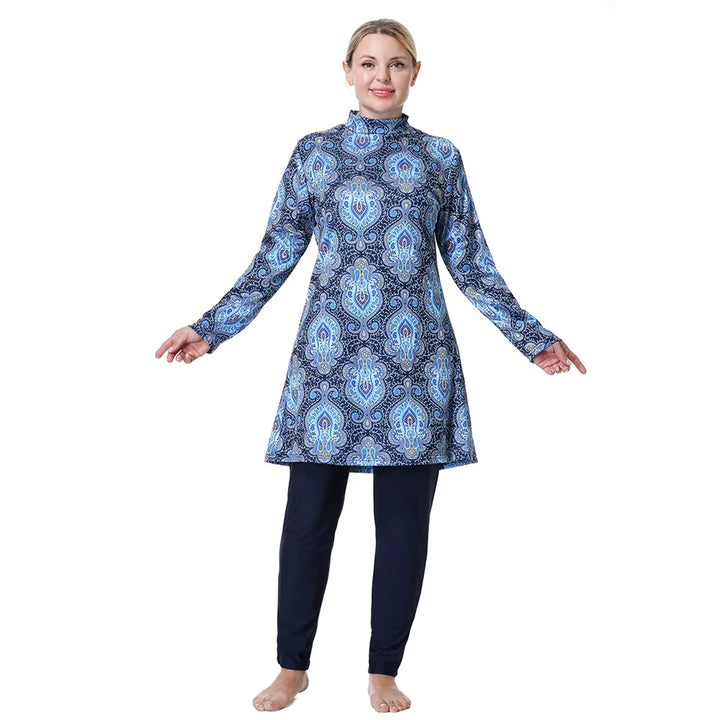 Woman wearing a blue patterned dress over black leggings on a white background