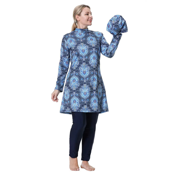 Woman wearing a blue patterned long-sleeve top and dark pants 