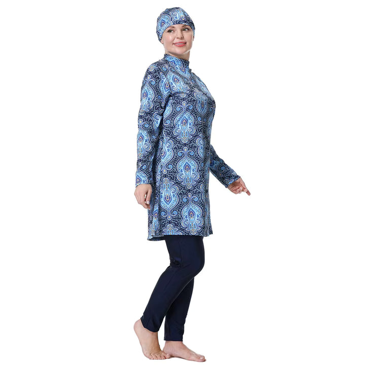 Woman wearing a blue patterned long-sleeve top and navy leggings on a white background