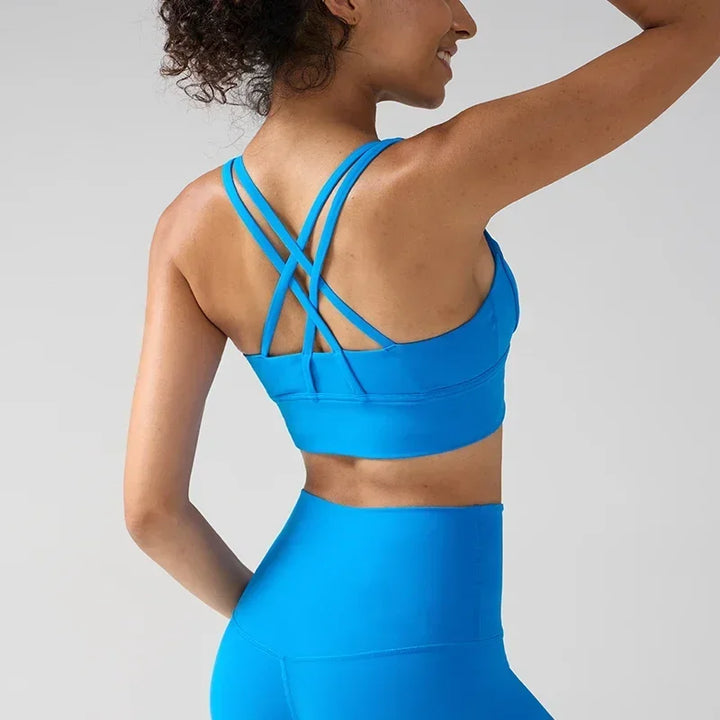 Person wearing a blue sports bra and leggings on a light gray background