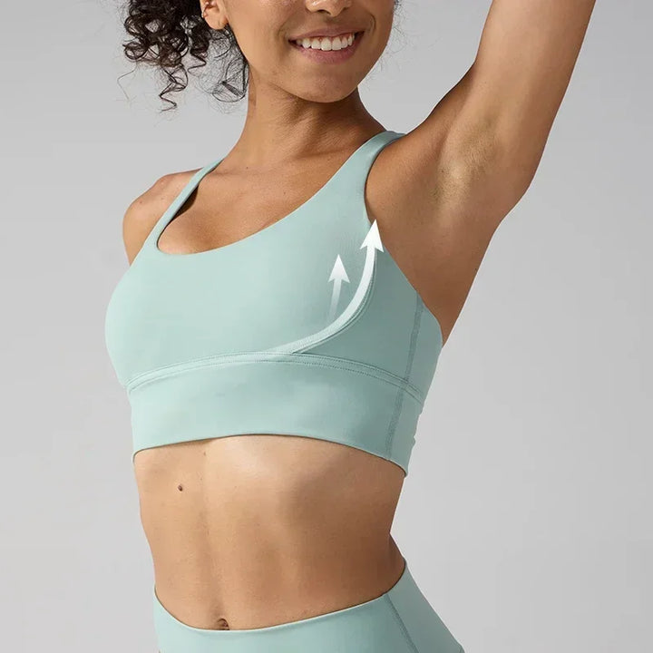 Woman wearing a light blue sports bra and leggings on a gray background