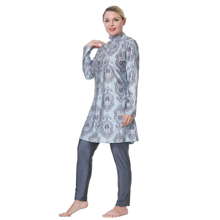 Woman wearing a patterned long-sleeve top and gray pants 