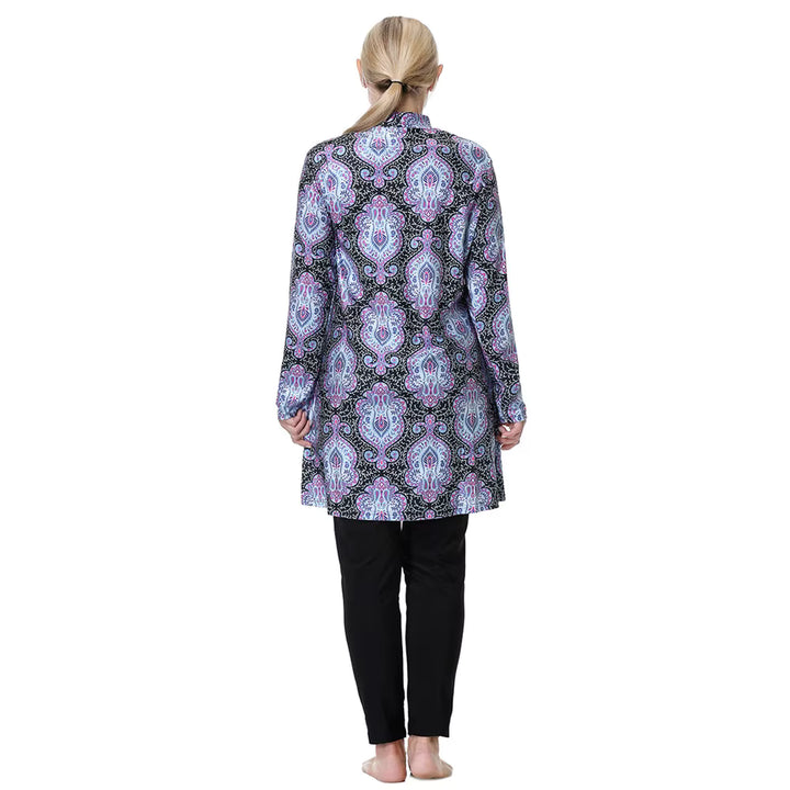 Woman wearing a patterned modest swimwear and black pants on a white background