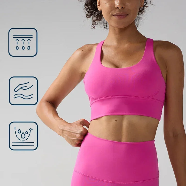 Woman wearing a pink sports bra and leggings with icons indicating fabric care instructions on a gray background.