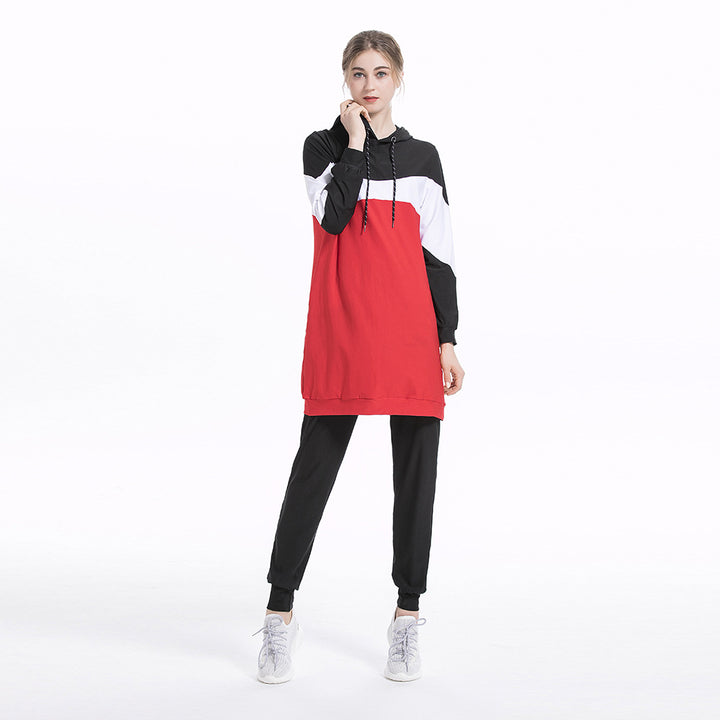 Woman wearing a red, black, and white color-blocked hoodie and pants on a white background