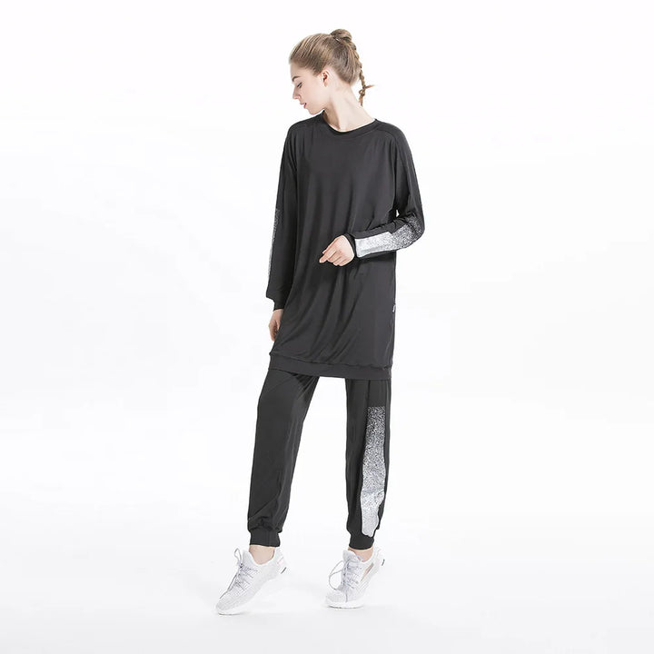Woman wearing black modest athletic wear set with colorblock sleeves and leggings