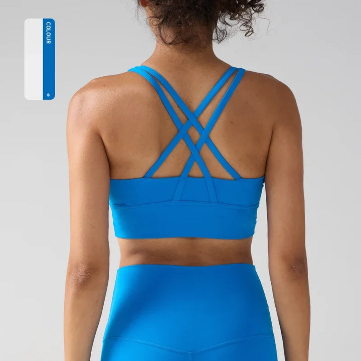 lady wearing a blue sports bra and leggings on a light gray background